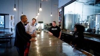 Barack Obama speaks with a bartender