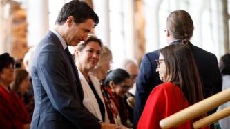 PM Trudeau shakes hands with a woman
