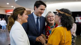 Sophie Grégoire Trudeau and PM Trudeau speak with a woman