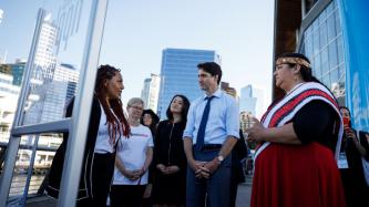 PM Trudeau and Minister Monsef listen to a woman