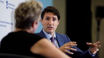 PM Trudeau speaks to a woman on stage