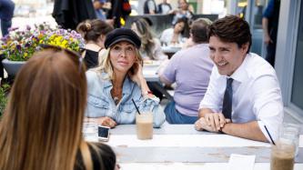 Le PM Trudeau rit avec deux femmes
