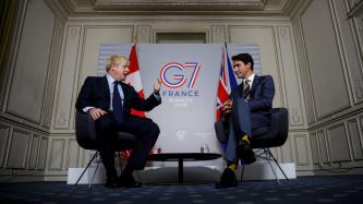 PM Trudeau listens to PM Johnson speak