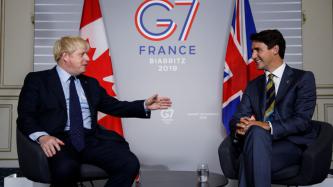PM Trudeau smiles as PM Johnson speaks