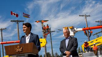 PM Trudeau stands at the podium while Premier Horgan looks on