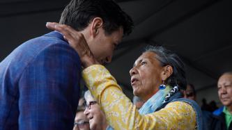 An elderly woman embraces PM Trudeau