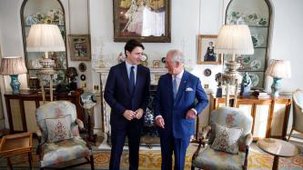 Prince Charles stands with PM Trudeau smiling