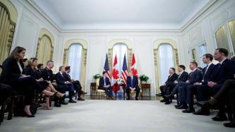 PM Trudeau and President Trump sit with dignitaries looking on
