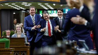 Conservative Leader Andrew Scheer and Prime Minister Justin Trudeau hold Anthony Rota by the arms