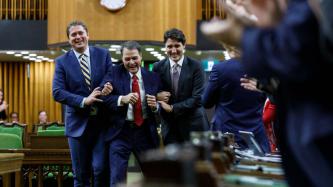 Conservative Leader Andrew Scheer and Prime Minister Justin Trudeau hold Anthony Rota by the arms