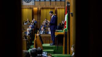 Anthony Rota stands at the Speaker’s chair gesturing with his hands