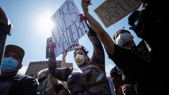 Protesters hold signs up in a crowd