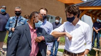 Le PM Trudeau salue un bénévole d’un coup de coude