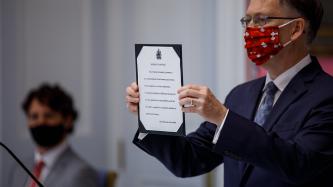 Clerk Ian Shugart holds a document representing an Oath of Office