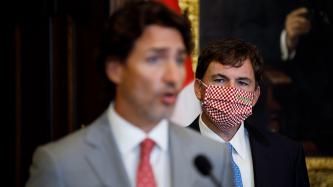Le ministre LeBlanc regarde le premier ministre Trudeau s'adresser aux médias