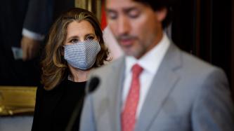 DPM Freeland looks at Prime Minister Trudeau speaking to the media