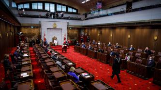 The Usher of the Black Rod walks in the Senate chamber