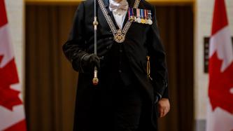 The Usher of the Black Rod enters the Senate chamber