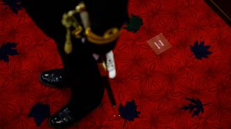 The Usher of the Black Rod stands on the Senate floor
