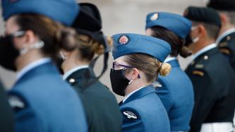 Des membres des FAC, debout dans une rangée, regardent
