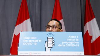 Dr. Njoo behind a COVID Alert podium card