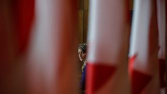 A view of Minister Joly, behind the Canadian flags