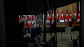 Vue du PM Trudeau et de la ministre Joly derrière une fenêtre