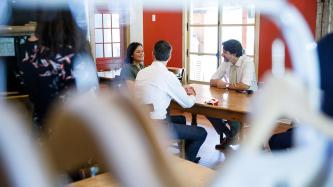 PM Trudeau, MP Amos, and a woman sit at a table