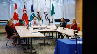 PM Trudeau and four women sit around a table and a nearby projector