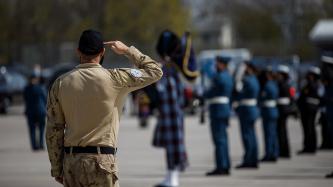 A military member stands in salute position