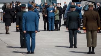 A military member hugs family and friends of members of the CAF