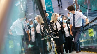 PM Trudeau speaks with a woman while using an escalator