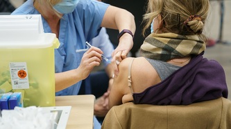 A nurse administers a vaccine to a woman
