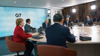 View of a meeting underway with leaders seated at a large round table