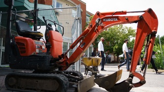 Le PM Trudeau marche derrière une excavatrice de marque Kubota