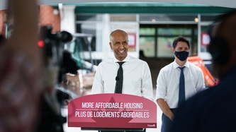 Le PM Trudeau et le ministre Hussen sont debout derrière un lutrin
