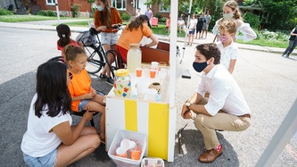 Le PM Trudeau parle à une fillette à un kiosque de limonade