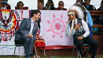 Le PM Trudeau et le chef Cadmus Delorme de la Première Nation de Cowessess sont assis et se sourient