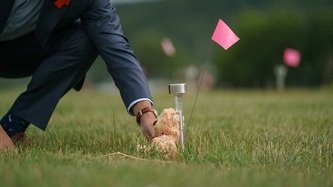 PM Justin Trudeau places a teddy bear against a solar light and small pink flag in the ground
