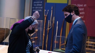 Ms. Mary Simon holds an object in her hand as Prime Minister Justin Trudeau looks on