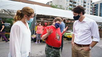 Le PM Trudeau et Sophie discutent avec un homme à un marché local