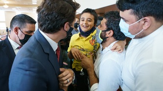PM Trudeau greets a man and a young boy