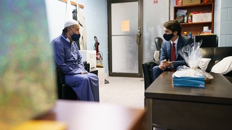 PM Trudeau speaks with a man in a room