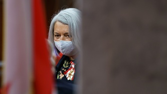 A view of the Governor General behind the Canadian flag