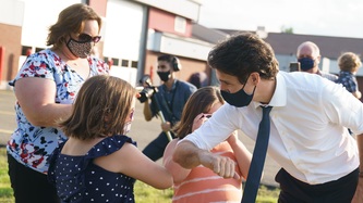 PM Trudeau bumps elbows with a young girl