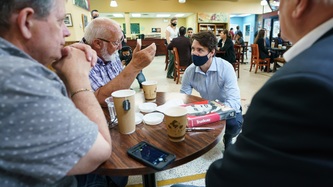 PM Trudeau kneels to talk to a man