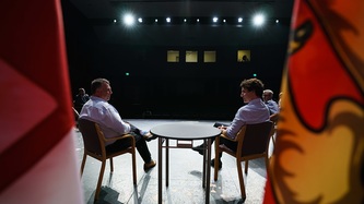 PM Trudeau and Premier King of Charlottetown sit on a stage