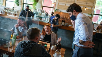 Une femme s’esclaffe tandis que le PM Trudeau se tient les mains sur la hanche