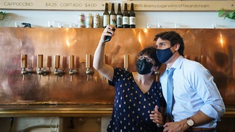A woman holds a phone for a selfie with PM Trudeau