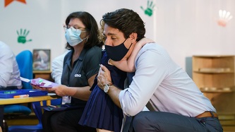 A young child hugs PM Trudeau